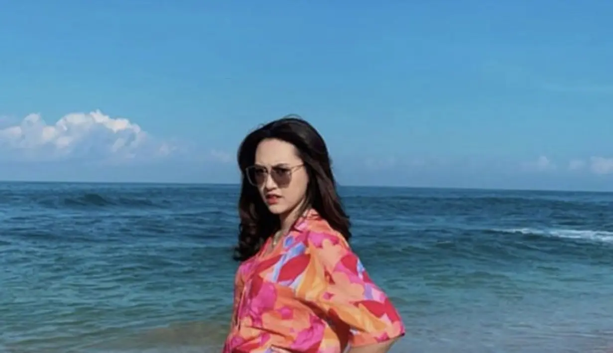 Happy juga tampak colorful dengan pakaian two pieces yang terdiri dari kemeja dan short pantsnya. Lengkap mengenakan kacamata hitam. (@happy_asmara77)