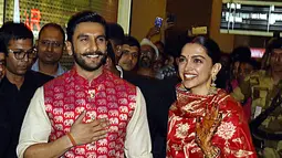 Pasangan bintang Bollywood India, Ranveer Singh dan Deepika Padukone menyapa penggemar yang menyambut mereka di bandara Mumbai, Minggu (18/11). Setelah pacaran selama 5 tahun, Deepika dan Ranveer akhirnya resmi melangsungkan pernikahan di Italia. (AFP)