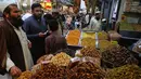Kurma, menjadi buah yang paling banyak dibeli untuk sajian berbuka puasa. Tampak dalam foto, orang-orang mengunjungi pasar untuk membeli kurma dan barang-barang lainnya sebagai persiapan untuk bulan puasa Ramadan yang akan datang, di Peshawar, Pakistan, Senin, 16 Februari 2026. (AP Photo/Muhammad Sajjad)