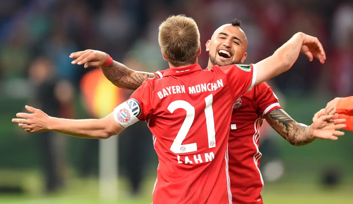 Pemain Bayern Munchen, Philipp Lahm, merayakan kemenangan atas Borussia Dortmund bersama Arturo Vidal dalam final DFB Pokal di Olympiastadion Berlin, Sabtu (25/5/2016). (AFP/Christof Stache) 