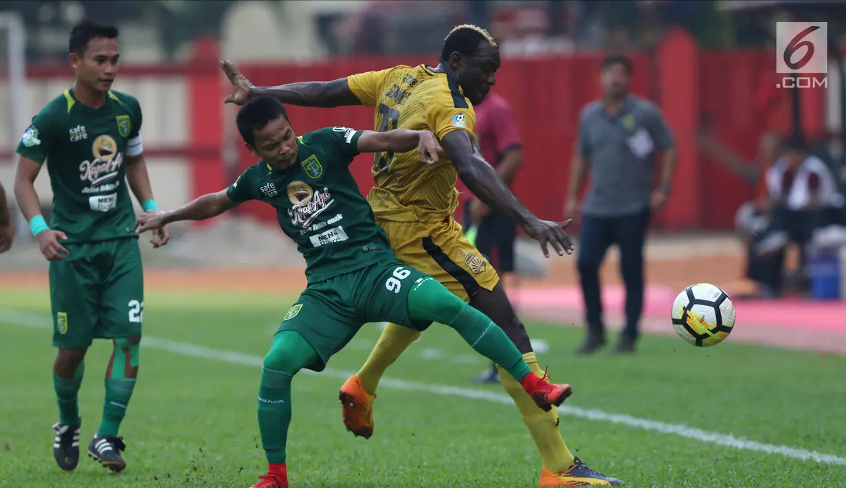 Pemain Bhayangkara FC, Herman Dzumafu (kanan) berebut bola dengan pemain Persebaya pada lanjutan Go-Jek Liga 1 Indonesia bersama Bukalapak di Lapangan PTIK, Jakarta, Rabu (11/7). Babak pertama, Bhayangkara FC unggul 2-1. (Liputan6.com/Helmi Fthriansyah)