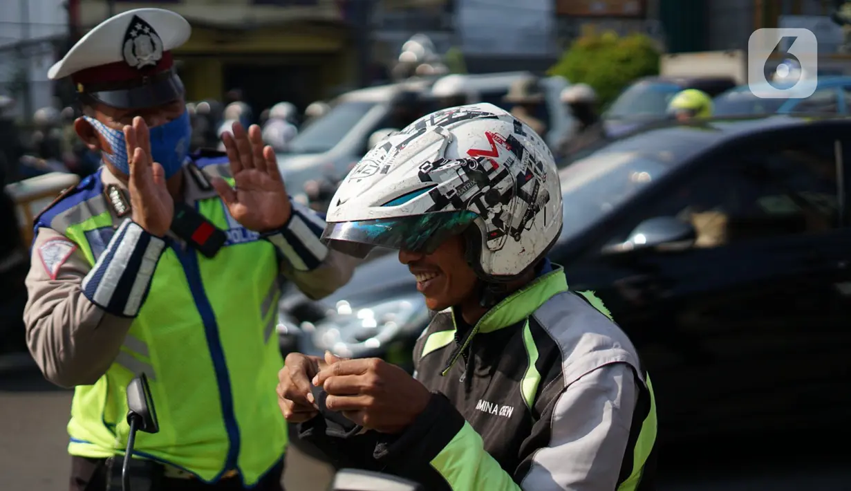 Polisi melakukan sosialisasi penggunaan masker kepada pengendara sepeda motor di kawasan Depok, Jawa Barat, Senin (20/7/2020). Setelah sosialisasi, Pemkot Depok akan menerapkan sanksi denda kepada warga yang melanggar. (Liputan6.com/Immanuel Antonius)