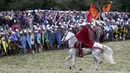 Seorang warga menaiki kuda saat ikut mereka ulang Pertempuran Hasting di Battle, Inggris, (15/10). Pertempuran Hasting ini juga disebut sebagai peperangan yang telah mengubah garis besar Inggris. (REUTERS/Neil Balai)