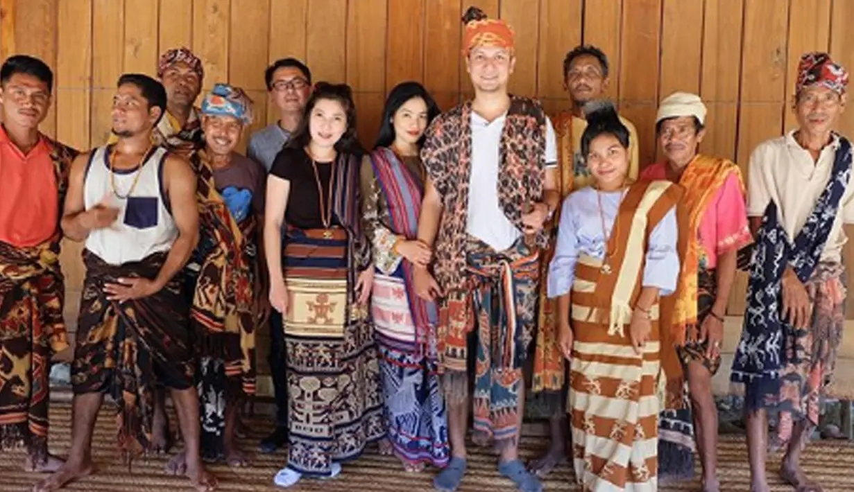 Mengenakan kain khas sumba, Titi kamal dan Christian Sugiono berfoto bersama rekan serta warga lokal (Liputan6.com/IG/titi_kamall)