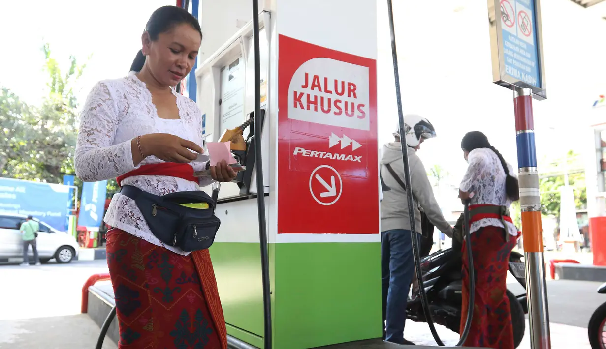 Petugas dengan pakaian adat mengisi bahan bakar minyak (BBM) untuk sepeda motor di SPBU, Bali, Rabu (10/10). Petugas SPBU mengenakan pakaian adat Bali untuk menyambut pertemuan tahunan IMF dan Bank Dunia. (Liputan6.com/Angga Yuniar)
