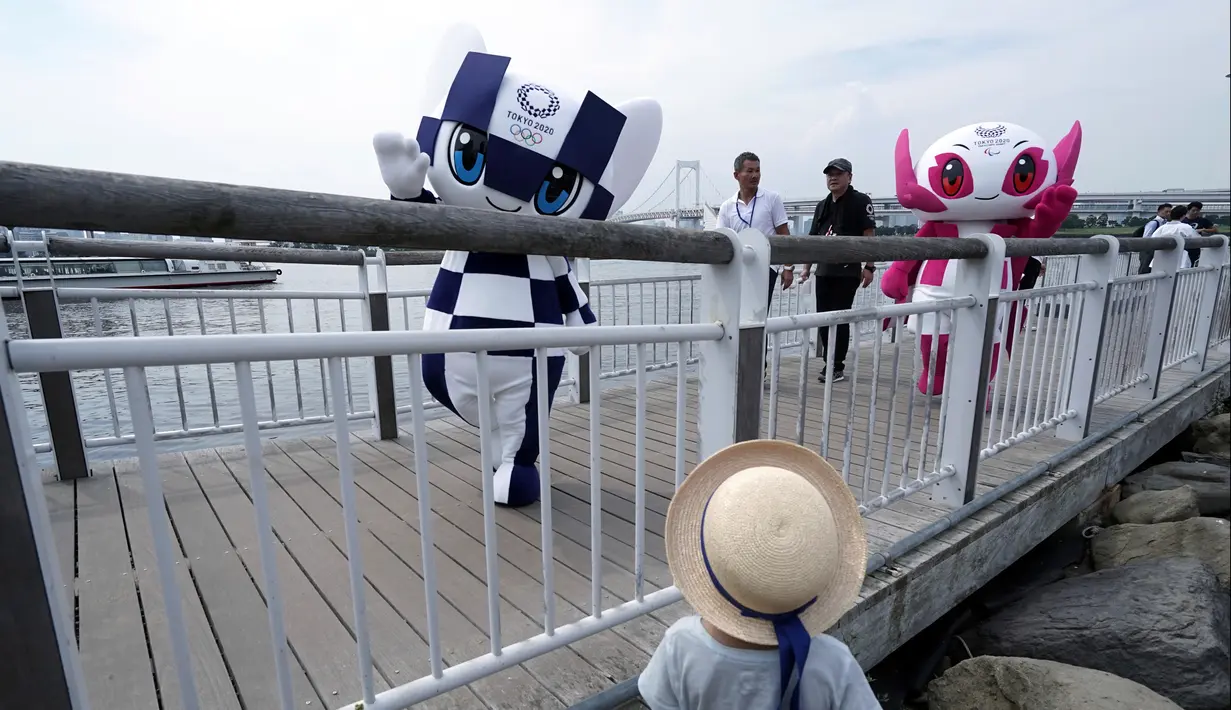Maskot Olimpiade dan Paralimpik Tokyo 2020, Miraitowa (kiri) dan Someity (kanan) berjalan di dermaga saat debut mereka di Tokyo, Jepang, Minggu (22/7). Menurut panitia, Miraitowa dan Someity memiliki keramahan yang luar biasa. (AP Photo/Eugene Hoshiko)