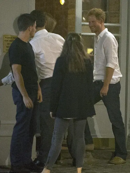 Pangeran Harry bercanda dengan pengunjung pub sembari meninggalkan lokasi tersebut setelah merayakan ulang tahunnya dengan pesta selama lima jam. (via dailymail.co.uk)