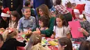 Ibu Negara AS Melania Trump membantu anak-anak membuat kartu Natal di Kampanye Program Korps Marinir AS "Toys For Tots" di Joint Base Anacostia-Bolling, Washington (13/12). Acara ini merupakan kegiatan menyambut Natal di AS. (AFP Photo/mandel Ngan)