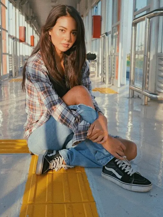 Lagi-lagi Aurelie menggerai rambutnya yang panjang dan berwarna cokelat itu. Kali ini ia memakai ripped jeans dan kemeja kotak-kotaknya. Keren banget kan? (Instagram/aurelieowreally)