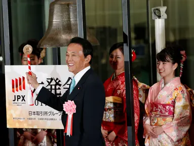 Wakil Perdana Menteri Jepang sekaligus Menteri Keuangan Jepang, Taro Aso didampingi gadis berkimono saat pembukaan tahun baru Bursa Efek Tokyo (TSE), Jepang (4/1).  (Reuters/Kim Kyung-Hoon)