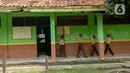 Sejumlah murid berjalan melewati gedung SDN Samudrajaya 04 yang rusak, Desa Samudrajaya, Kecamatan Tarumajaya, Kabupaten Bekasi, Jawa Barat, Selasa (21/1/2020). Murid SDN Samudrajaya 04 terpaksa belajar di gedung sekolah yang rusak sejak tahun 2014. (merdeka.com/Imam Buhori)