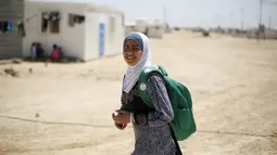 Omayma berjalan pulang sekolah di kamp pengungsi Al Zaatari, Mafraq, Yordania (21/4). Omayma Al Hushan menyerukan perlawanan terhadap pernikahan dini yang marak negaranya. (REUTERS / Muhammad Hamed)