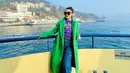 OOTD penuh warna dari Fitri Carlina saat liburan. Ia mengenakan kaus ungu bermotif tulisan, dipadu dengan denim pants, coat panjang berwarna hijau terang, sneakers putih, dan sunglasses. [Foto: Instagram/fitricarlina]
