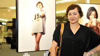 Dewi Rezer narsis di samping foto dirinya saat hadiri pameran tunggal Jerry Aurum, Senayan City, Jakarta, Rabu (17/9/2014) (Liputan6.com/Panji Diksana)