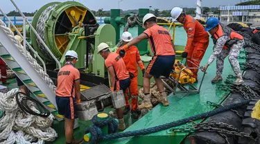 Personel penjaga pantai Filipina memuat peralatan skimmer yang akan digunakan dalam penanggulangan tumpahan minyak di sebuah pelabuhan di Limay, Bataan pada tanggal 26 Juli 2024. (Jam Sta Rosa/AFP)