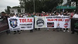 Demonstran driver online membentangkan spanduk dalam unjuk rasa  di depan Istana Negara, Jakarta, Rabu (14/2). Massa meneriakkan suaranya meminta Menteri Perhubungan Budi Karya, untuk menghapus Permenhub 108 tahun 2017. (Liputan6.com/Arya Manggala)