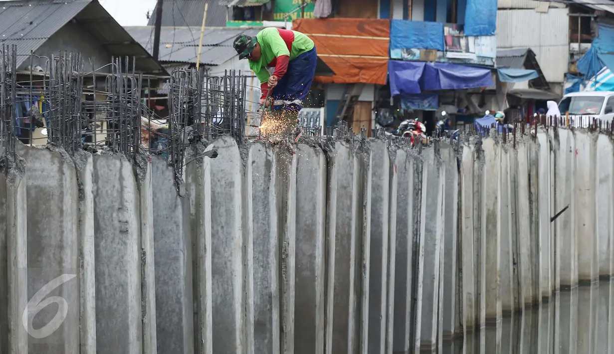 Seorang pekerja menyelesaikan pemasangan turap Kali Gendong di Penjaringan, Jakarta, Senin (10/10). Normalisasi kawasan bantaran kali Gendong saat ini terus dikerjakan sebagai bagian dari normalisasi kawasan Waduk Pluit. (Liputan6.com/Gempur M Surya)