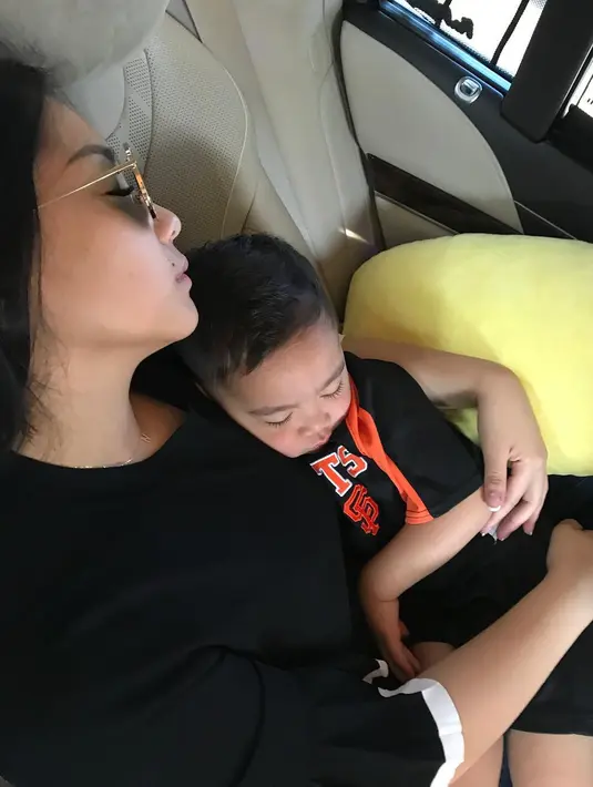 Nagita Slavina tampak tertidur di mobil. Ia tampak memeluk sang buah hati, Rafathar. (Foto: instagram.com/raffinagita1717)
