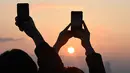 Menyaksikan detik-detik matahari terbenam atau sunset terakhir di tahun 2023 menjadi keasyikan tersendiri bagi sebagian warga. (Jung Yeon-je / AFP)