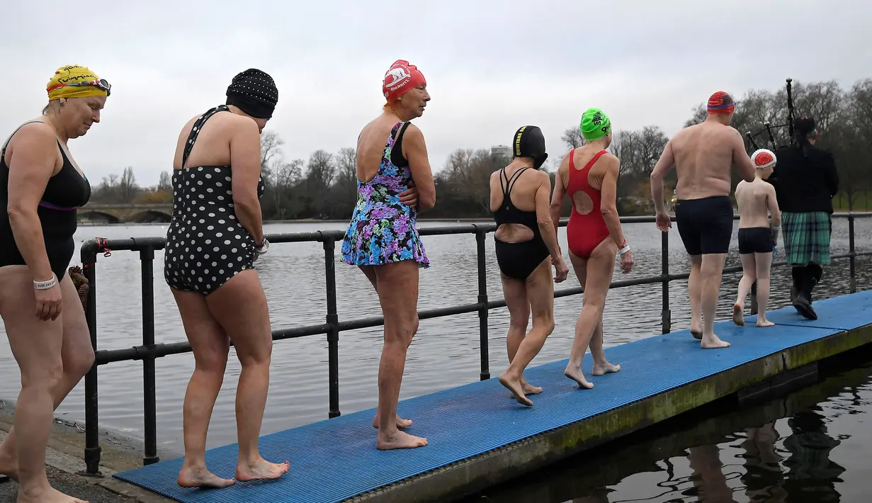 Sejumlah peserta bersiap untuk mengikuti lomba berenang di Danau Serpentine di Hyde Park, London, Inggris, Minggu (25/12). Lomba ini digelar untuk merayakan Natal 2016. (REUTERS/Toby Melville)