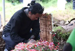 Konten kreator yang juga musisi, Reza Oktovian atau lebih dikenal dengan panggilan Reza Arap tertunduk di sisi nisan kekasihnya, Lula Lahfah, di Tempat Pemakaman Umum (TPU) Rawa Terate, Cakung, Jakarta Timur, pada Sabtu (24/1/2026). Selebgram Lula Lahfah dimakamkan di Tempat Pemakaman Umum (TPU) Rawa Terate, Cakung, Jakarta Timur, pada Sabtu (24/1/2026). (Kapanlagi.com/Budy Santoso)