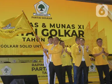 Ketua Umum Partai Golkar, Bahlil Lahadalia (kiri) mengibarkan panji Partai Golkar saat Rapat Pimpinan Nasional (Rapimnas) dan Musyawarah Nasional (Munas) XI Partai Golkar 2024 di Jakarta Convention Center, Rabu (21/8/2024). (Liputan6.com/Herman Zakharia)