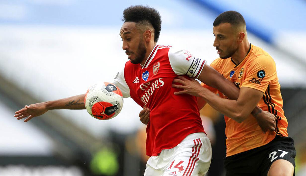 Striker Arsenal, Pierre-Emerick Aubameyang, berebut bola dengan pemain Wolverhampton Wanderers, Romain Saiss, pada laga Premier League di Stadion Molineux, Sabtu (4/6/2020). Arsenal menang dengan skor 2-0. (AP/Michael Steele)