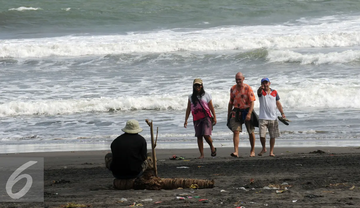Wisatawan berjalan jalan di pinggir Pantai Depok, Bantul, Yogyakarta, Minggu (27/3/2016). Pantai Depok menjadi lokasi wisata di Daerah Istimewa Yogyakarta yang ramai dikunjungi saat musim libur tiba. (Liputan6.com/Helmi Fithriansyah)