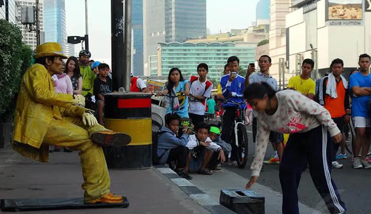  Salah satu pengunjung tampak memasukkan uang dalam kotak yang disiapkan manusia patung (Liputan6.com/Miftahul Hayat) 