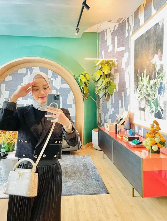 Untuk acara formal, tampilan Dinda Hauw yang memadukan cropped blazer dan rok plisket warna hitam ini memberikan kesan elegan. Untuk hijab, bisa pilih warna abu-abu. (Instagram/dindahw).