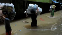 Intensitas curah hujan yang tinggi sejak Minggu (8/2) membuat Sungai Pesanggrahan meluap. Tampak sejumlah pedagang memindahkan barang dagangannya di Pasar Cipulir, Jakarta, Selasa (10/2/2015).(Liputan6.com/Andrian M Tunay)