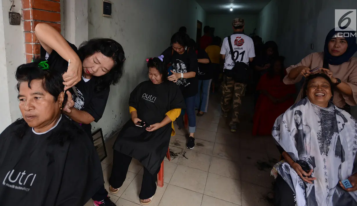 Warga RW 1 Koja, Jakarta Utara, menikmati potong rambut gratis, Jakarta, Sabtu (1/12). Kegiatan tersebut diselenggarakan Sahabat Indonesia Maju (SIMA) dan sebagai bentuk bakti sosial kepada masyarakat. (Merdeka.com/Imam Buhori)