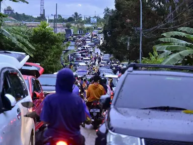 Warga memadati jalan saat mereka mencoba meninggalkan Mamuju usai diguncang gempa, Sulawesi Barat, Indonesia, Jumat (15/1/2021). Sejumlah rumah dan bangunan di Mamuju rusak akibat gempa magnitudo 6,2 yang berpusat di timur laut Majene. (Firdaus/AFP)