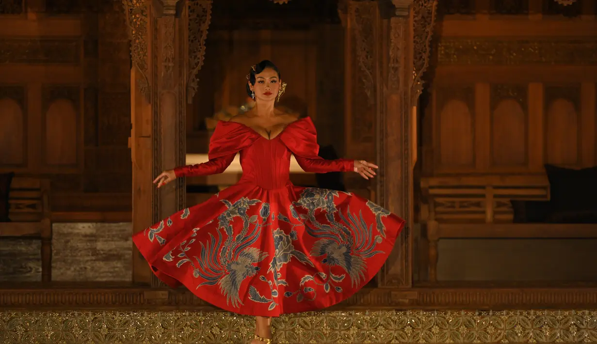 Jadi salah satu muse, Indah Kalalo tampil eksotis dengan gaun merah bermotif batik. Dress bergaya sabrina itu punya rok A-line yang menawan [dok. Sandyakala Smara]