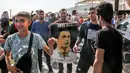 Sejumlah masyarakat Tehran membawa poster pemain Al-Nassr, Cristiano Ronaldo saat menyambut kedatangannya menjelang laga Liga Champions Asia 2023 melawan Persepolis FC, Selasa (19/09/2023). (AFP/Payam Parsae)
