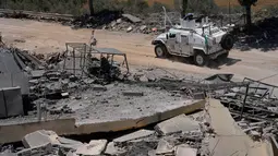 Kendaraan penjaga perdamaian Perserikatan Bangsa Bangsa (PBB) asal Spanyol melintas di depan sebuah rumah yang hancur dalam bentrokan antara Hizbullah dan militer Israel di desa Dibbine, Lebanon Tenggara, Jumat 5 Juni 2026. (AP Photo/Hussein Malla)