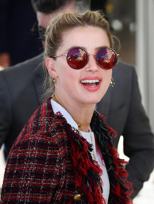 Aktris AS Amber Heard saat tiba untuk menghadiri malam pembukaan Festival Film Cannes ke-72 di Prancis (13/5/2019). Aktris 33 tahun ini mengenakan kaca mata merah, perhiasan emas, dan membawa tas rantai-tali YSL. (AFP Photo/Alberto Pizzoli)