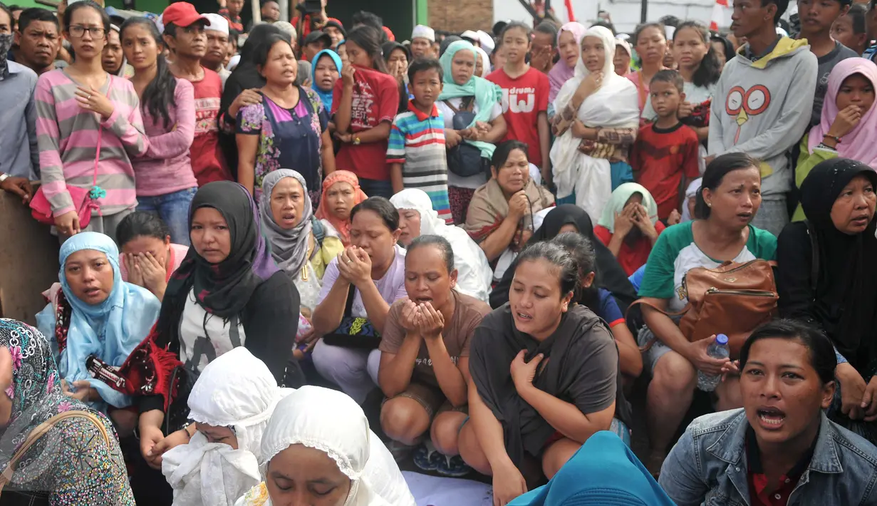 Sejumlah ibu menggelar doa bersama saat ekseksusi penggusuran di kawasan Pasar Ikan, Penjaringan, Jakarta, Senin (11/4). Para warga yang didominasi perempuan itu ikut menolak penggusuran kawasan tersebut. (Liputan6.com/Gempur M Surya)