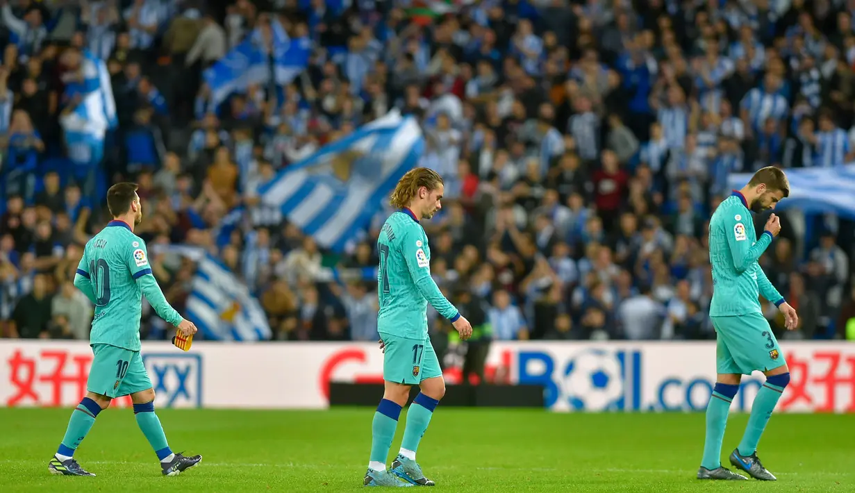 Para pemain Barcelona tampak kecewa usai ditahan imbang Real Sociedad pada laga La Liga di Stadion Anoeta, San Sebastian, Sabtu (14/12). Kedua klub bermain imbang 2-2. (AFP/Ander Gillenea)