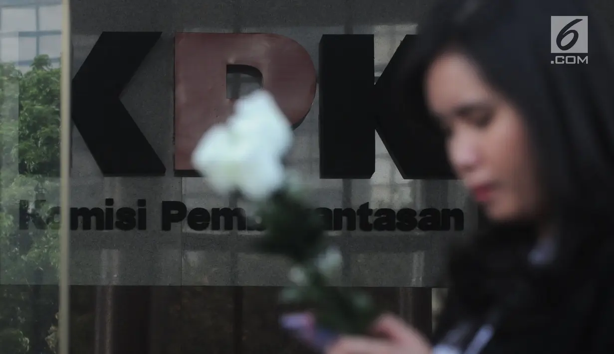Seorang wanita membawa bunga mawar menyambut kedatangan penyidik senior KPK, Novel Baswedan saat masuk kerja kembali di gedung KPK, Jakarta, Jumat (27/7). Hingga sekarang penyiram air keras  Novel belum di tangkap. (Merdeka.com/Dwi Narwoko)