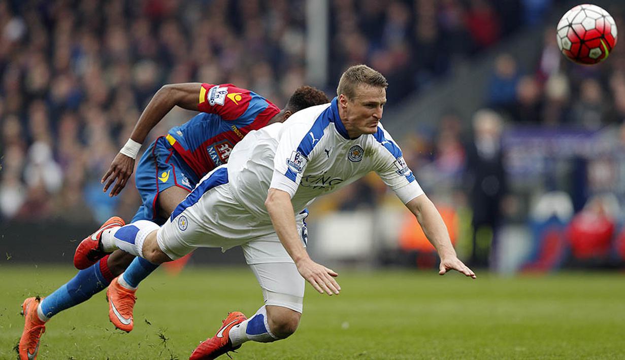 Bek Leicester, Robert Huth, membuang bola dari jangkauan pemain Crystal Palace pada laga Liga Premier Inggris di Stadion Selhurst Park, London, Sabtu (19/3/2016). Crystal Palace takluk 0-1 dari Leicester. (AFP/Adrian Dennis)