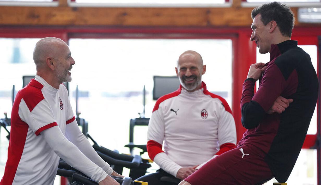 Striker baru AC Milan, Mario Mandzukic, berbincang dengan pelatih Stefano Pioli di Pusat Latihan AC Milan, Selasa (19/1/2021). Kehadiran Striker veteran asal Kroasia ini akan menambah ketajaman lini depan AC Milan. (Spada/LaPresse via AP)