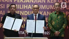 Sekretaris Jenderal KPU RI Bernad Dermawan Sutrisno (kiri), Dirjen Dukcapil Zudan Arif Fakrulloh (tengah), dan Ketua KPU RI Hasyim Asy'ari (kanan) menunjukkan dokumen saat penandatanganan perjanjian kerja sama antara Direktur Jenderal Dukcapil Kemendagri dengan Sekretaris Jenderal KPU RI di Gedung KPU, Jakarta, Rabu (29/6/2022). Kerja sama ini mengenai pemanfaatan nomor induk kependudukan, data kependudukan, dan kartu tanda penduduk elektronik dalam pemutakhiran data pemilih. (Liputan6.com/Angga Yuniar)