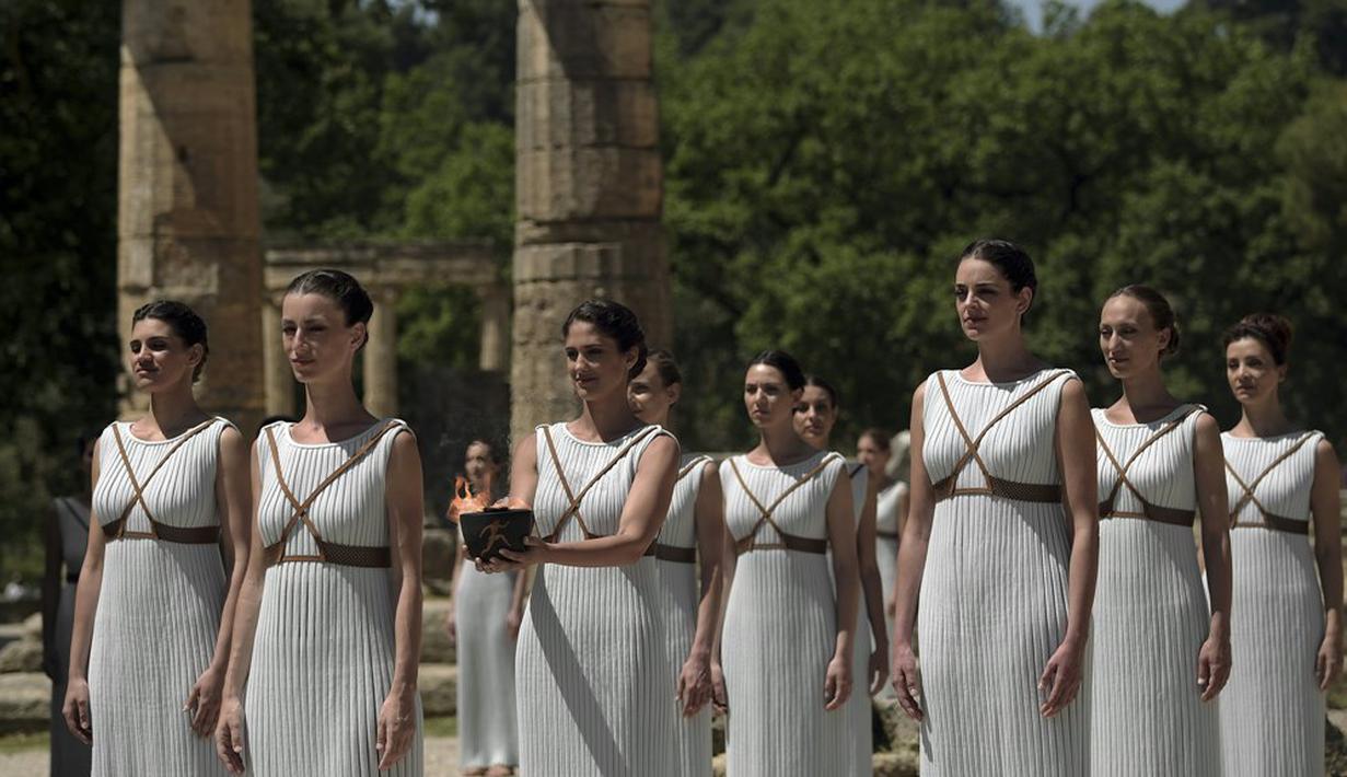 Para aktris membawa api olimpiade dalam suatu upacara di Candi Hera yang terletak di bekas kota tua Olympia, Yunani, Kamis (21/4/2016). (AFP/Aris Messinis)
