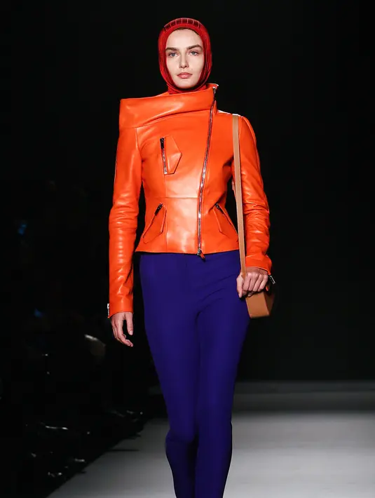 Model berjalan mengenakan hijab modern dan busana koleksi terbaru merek legendaris Paris, Lanvin di Paris Fashion Week Fall/Winter 2018/2019, Rabu (28/2). Lavin menyajikan warna hijab instan yang merebut perhatian penonton. (AP/Kamil Zihnioglu)