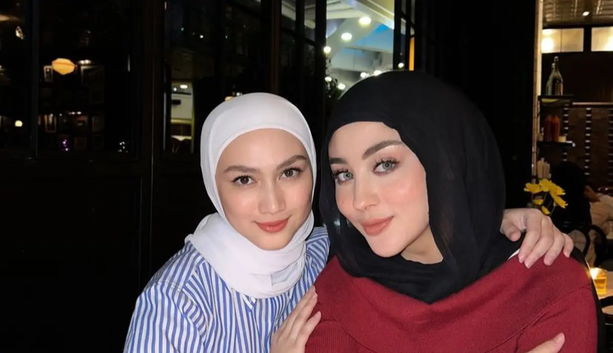Melody tampil mengenakan kemeja lengan panjang bergaris warna biru putih dipadukan kerudung putih. Margin tampil dengan atasan lengan panjang maroon dipadukan kerudung hitamnya.  [@dindahw]