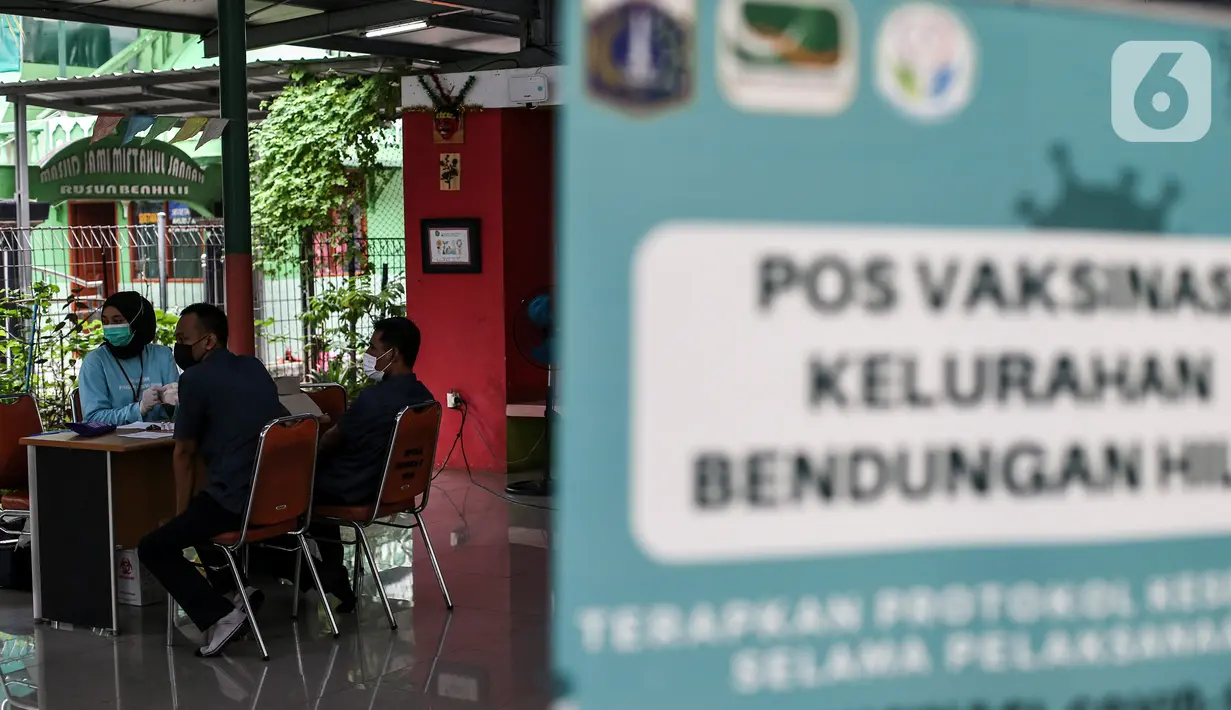 Petugas mendata warga yang akan disuntik vaksin COVID-19 dosis ketiga (booster) di RPTRA Rusun Benhil, Jakarta, Rabu (6/7/2022). Presiden Joko Widodo resmi menetapkan vaksinasi dosis ketiga atau vaksin booster jadi syarat untuk kegiatan masyarakat yang melibatkan masyarakat banyak. (Liputan6.com/Johan Tallo)