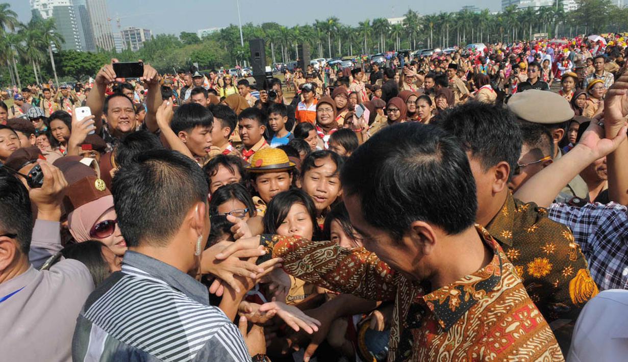 Pria yang akrab disapa Jokowi itu tiba pukul   09.00 WIB dan langsung diserbu ratusan siswa   peserta upacara dari tingkat SD hingga SMA   se-DKI Jakarta, Kamis (14/8/14).  (Liputan6.com/Herman Zakharia) 