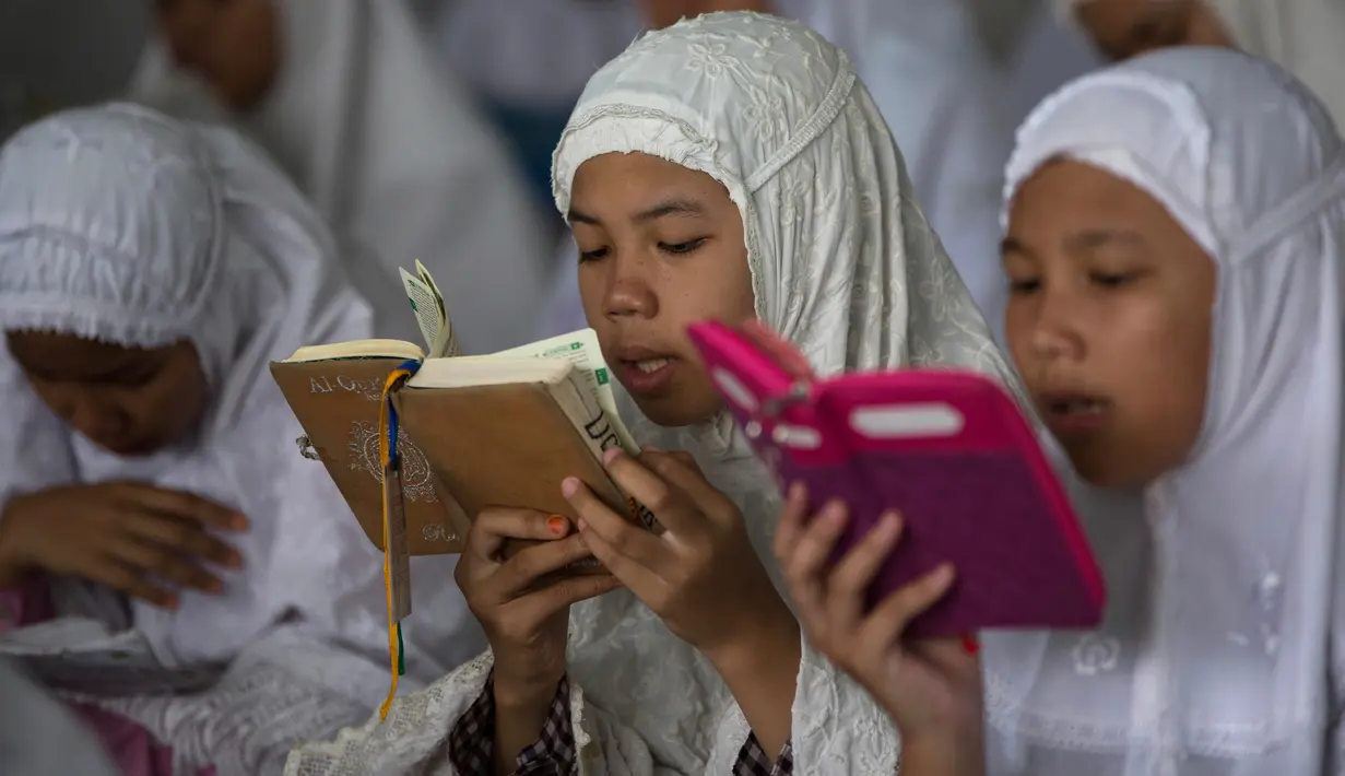 Santri membaca Al Quran saat tadarus massal awal Ramadhan 1440 H di Pesantren Ar-Raudhatul Hasanah, Medan, Sumatera Utara pada 6 Mei 2019. Tadarus yang diikuti sedikitnya 3.200 santri tersebut merupakan kegiatan rutin selama bulan Ramadan di pesantren tersebut. (AP/Binsar Bakkara)