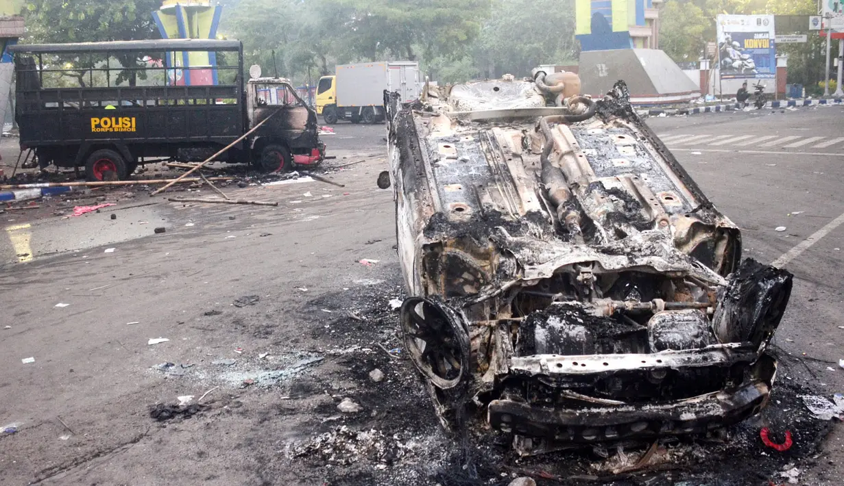 Terdapat 13 unit kendaraan polisi yang dilaporkan dirusak dan dibakar oleh oknum-oknum suporter. (AFP/Putri)